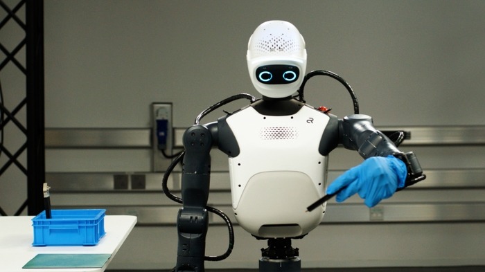 Mavi eldivenli bir Agile ONE SN insansı robotu, mavi bir kutunun üzerinde bir alet tutuyor